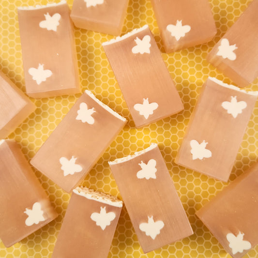 bars of honey-colored soaps featuring creamy colored bees in diagonal corners of each bar.