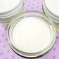 A closeup of an open jar of Sweet Dreams Body Lotion, showcasing the lotion inside.