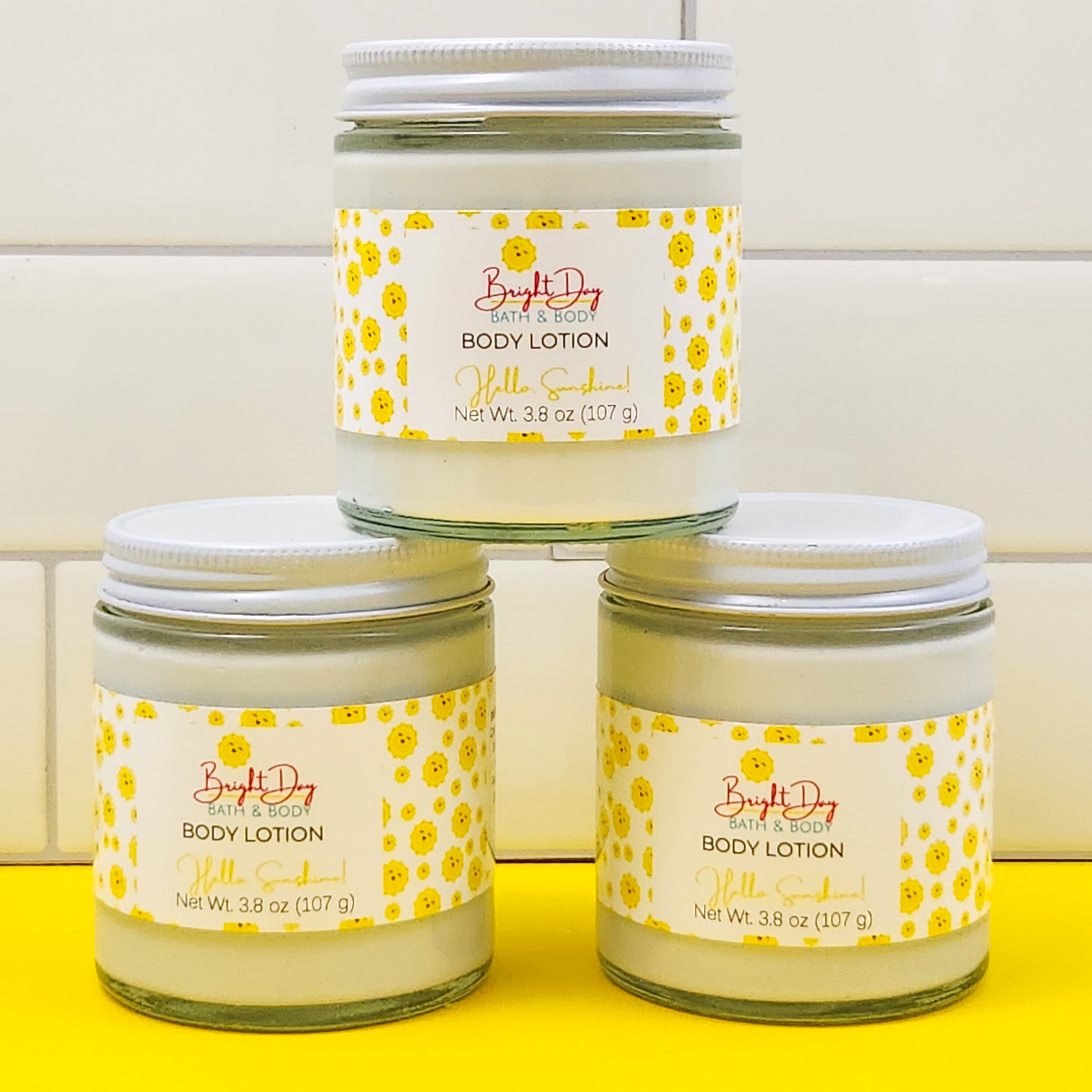 3 jars of Hello Sunshine lotion on a yellow and white background