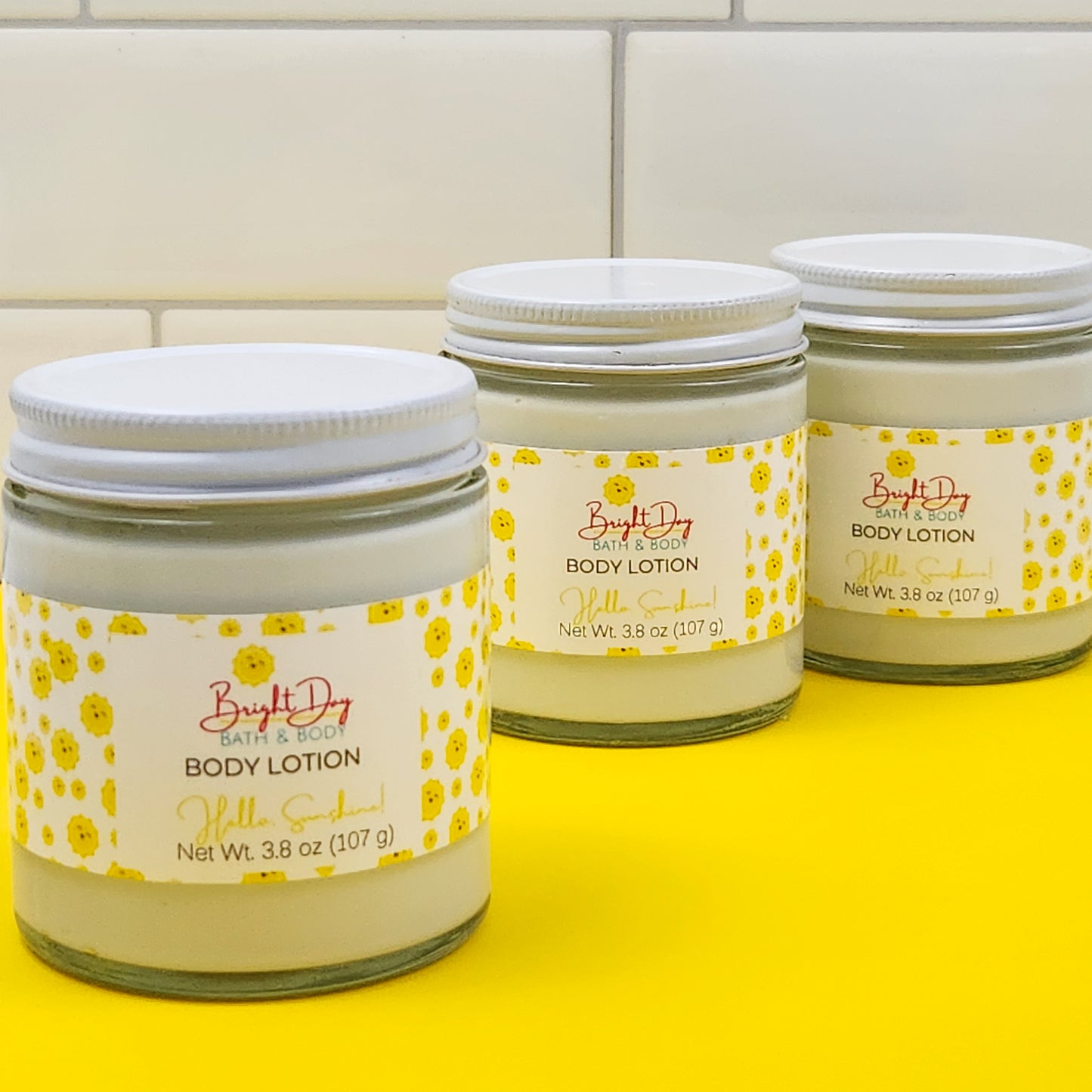 3 jars of Hello Sunshine lotion on a yellow background
