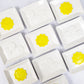 Alternating white rectangle soap dishes, some with 3 white hexagons in the middle, some with raised yellow sunshines in the middle