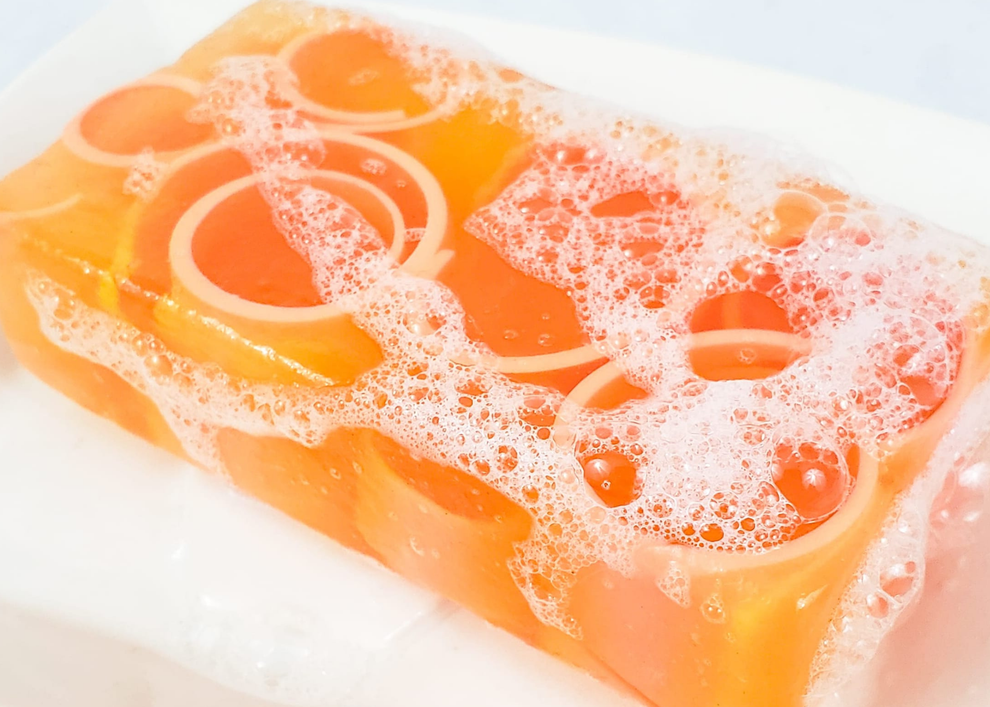 Orange bar of soap with bubbles on it