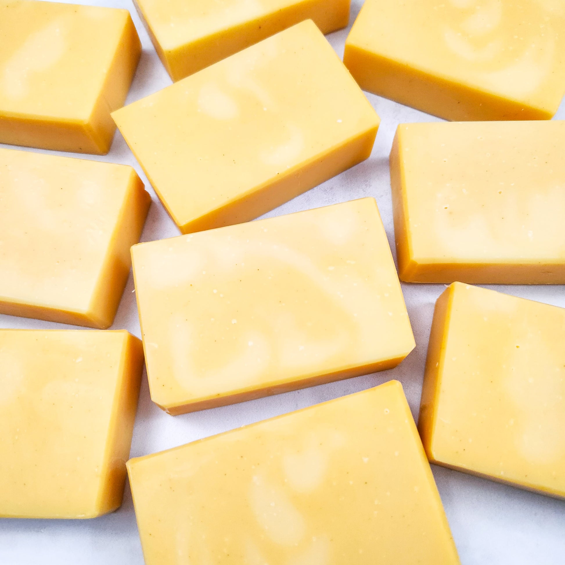 Several bats of yellowish orange soap on a white background