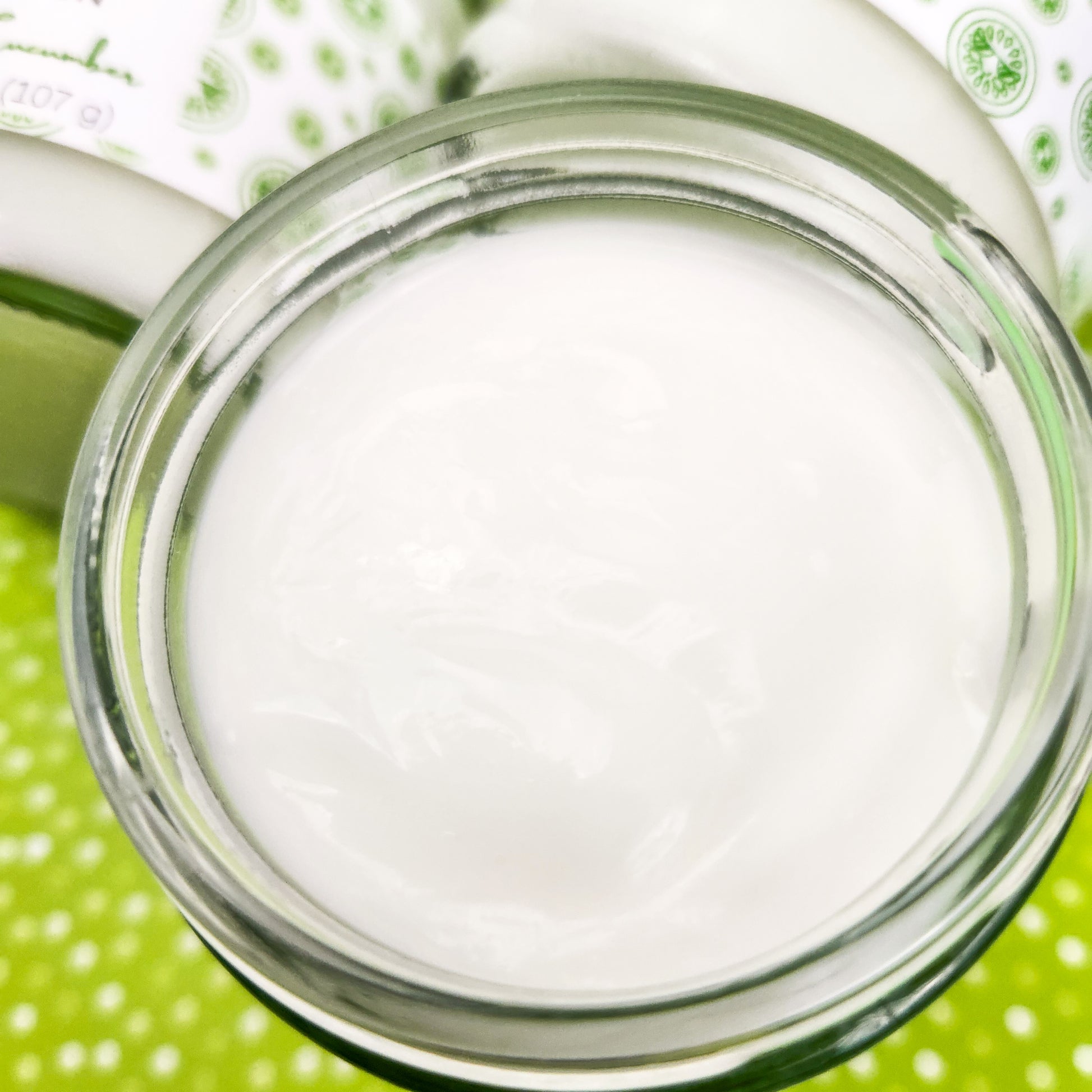 A closeup of an open jar of Cool as a Cucumber Body Lotion.