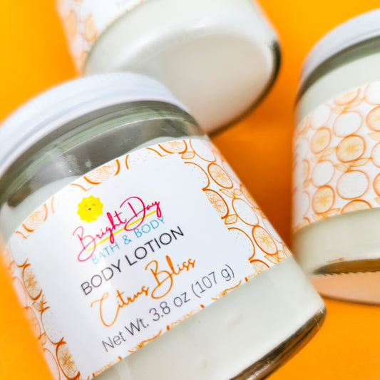 A closeup of a jar of Citrus Bliss Body Lotion, on an orange background