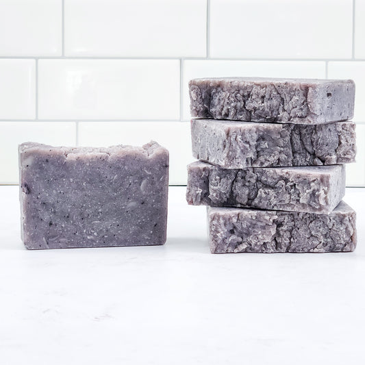 Stack of rustic, blue-gray colored soaps on a white background 