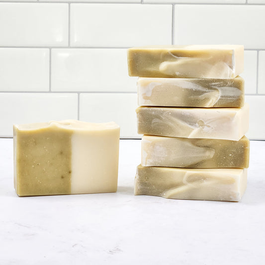 A stack of soap bars in a design half white and half green.