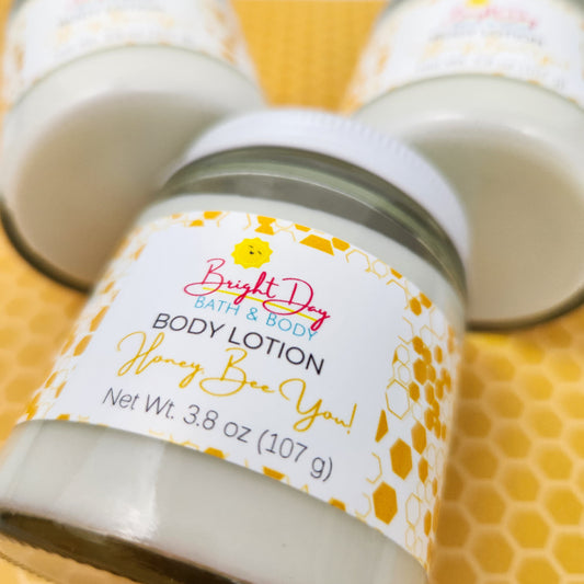 A closeup of a jar of Honey, Bee You Body Lotion, on a tan honeycomb background.
