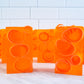 Several transparent orange bars of soap, with dark orange soap curls inside