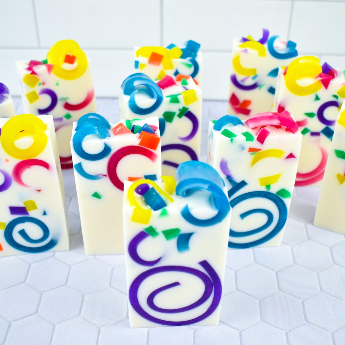 White bars of soap with multicolored curls and chunks embedded in them.