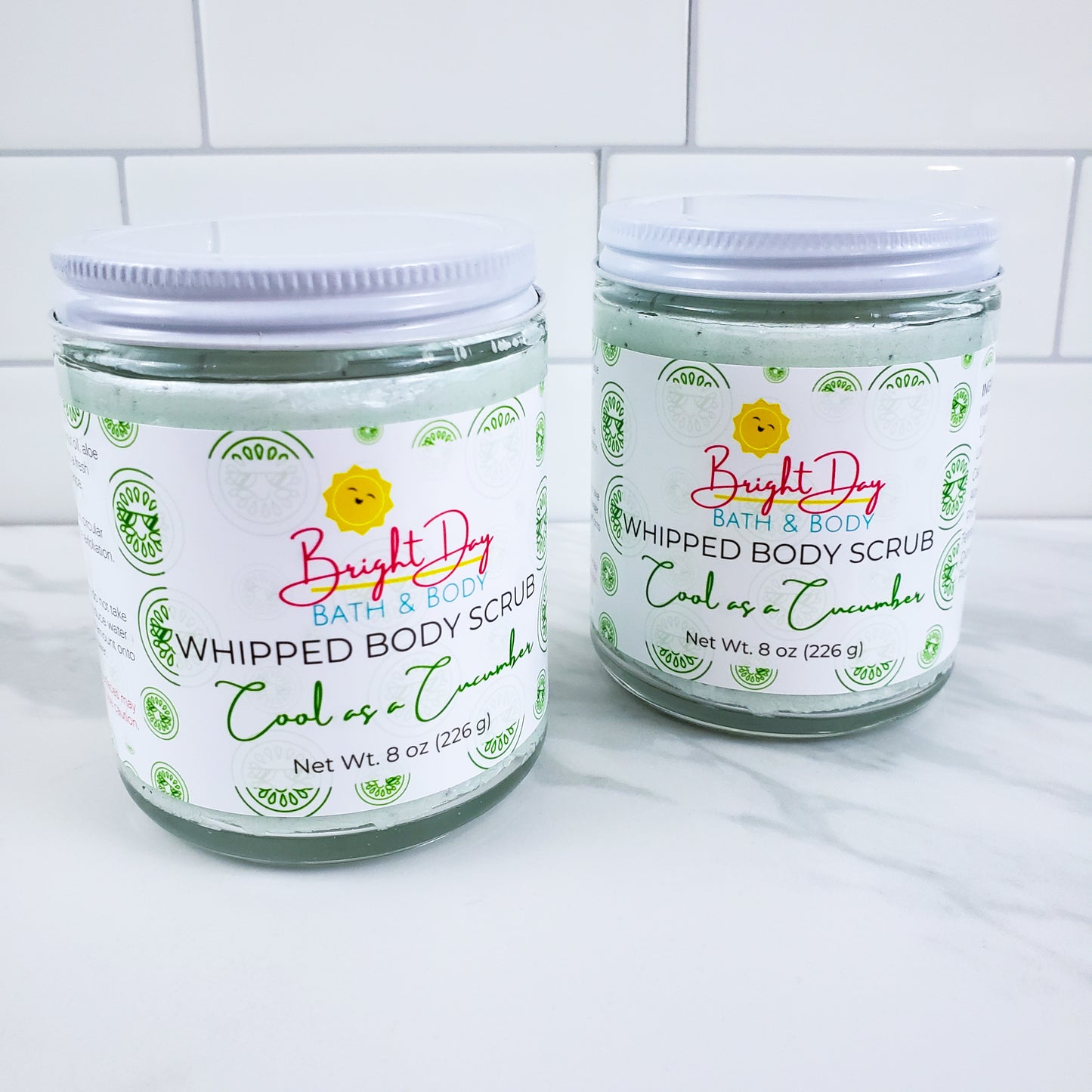 Two Cool as a Cucumber Body Scrubs on a tile background