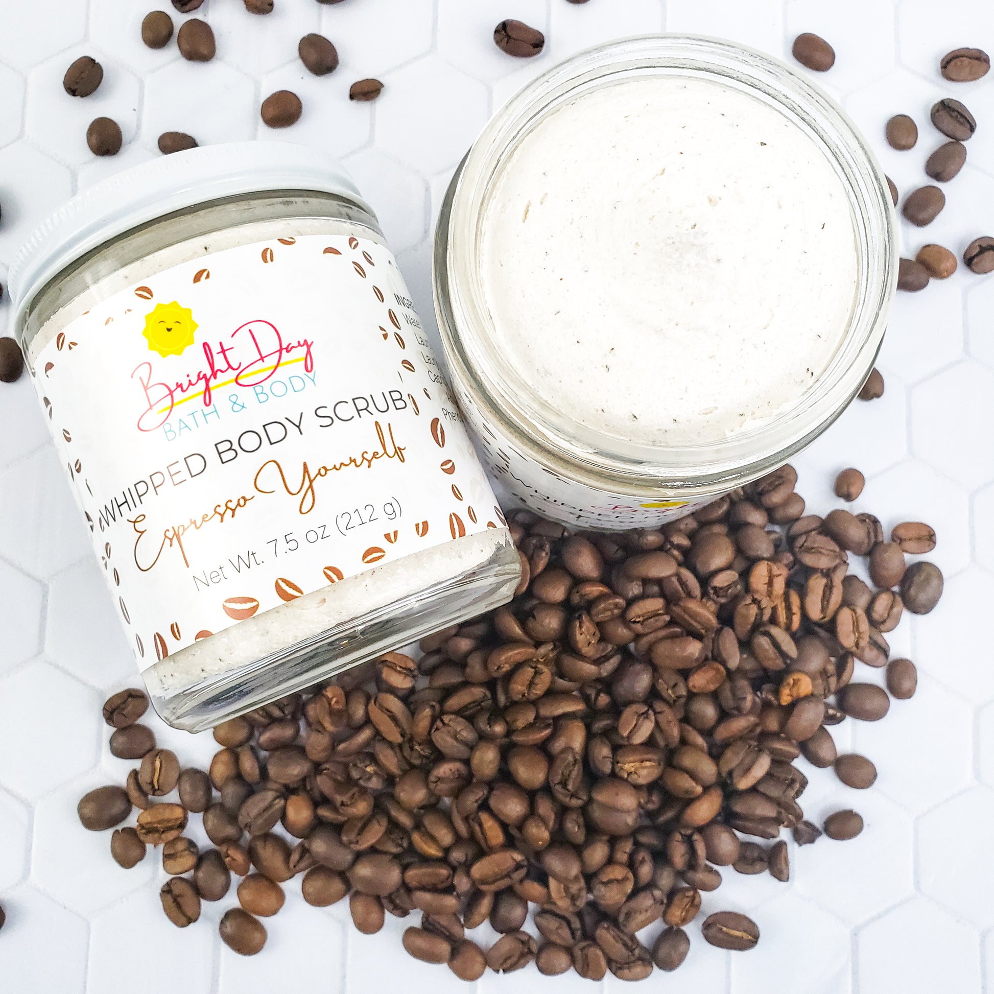 Two Espresso Yourself Body Scrub jars surrounded by coffee beans