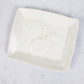 A white rectangular soap dish with 3 white hexagons in the middle